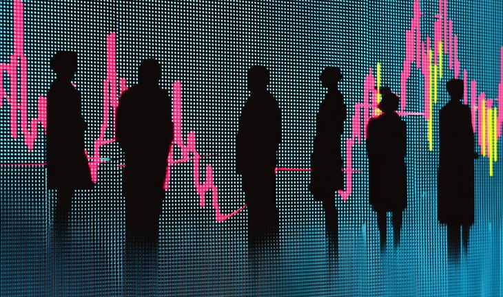 Silhouettes in front of market data