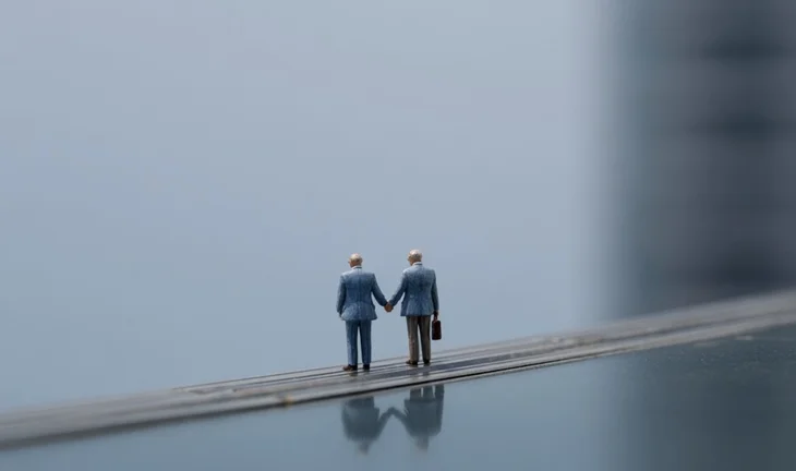Small plastic bankers holding hands 